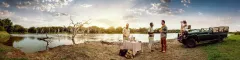 Banner Panoramic of a French couple enjoying refreshments at the side of a lake in Phinda